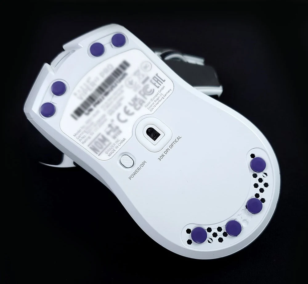 X-Raypad Obsidian Air purple dot skates fitted to the underside of a white gaming mouse